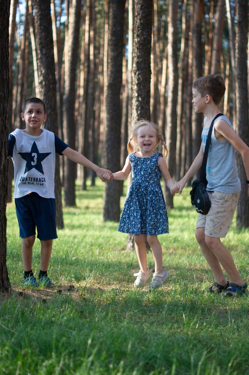 Kinder gehen Hand in Hand durch den Wald